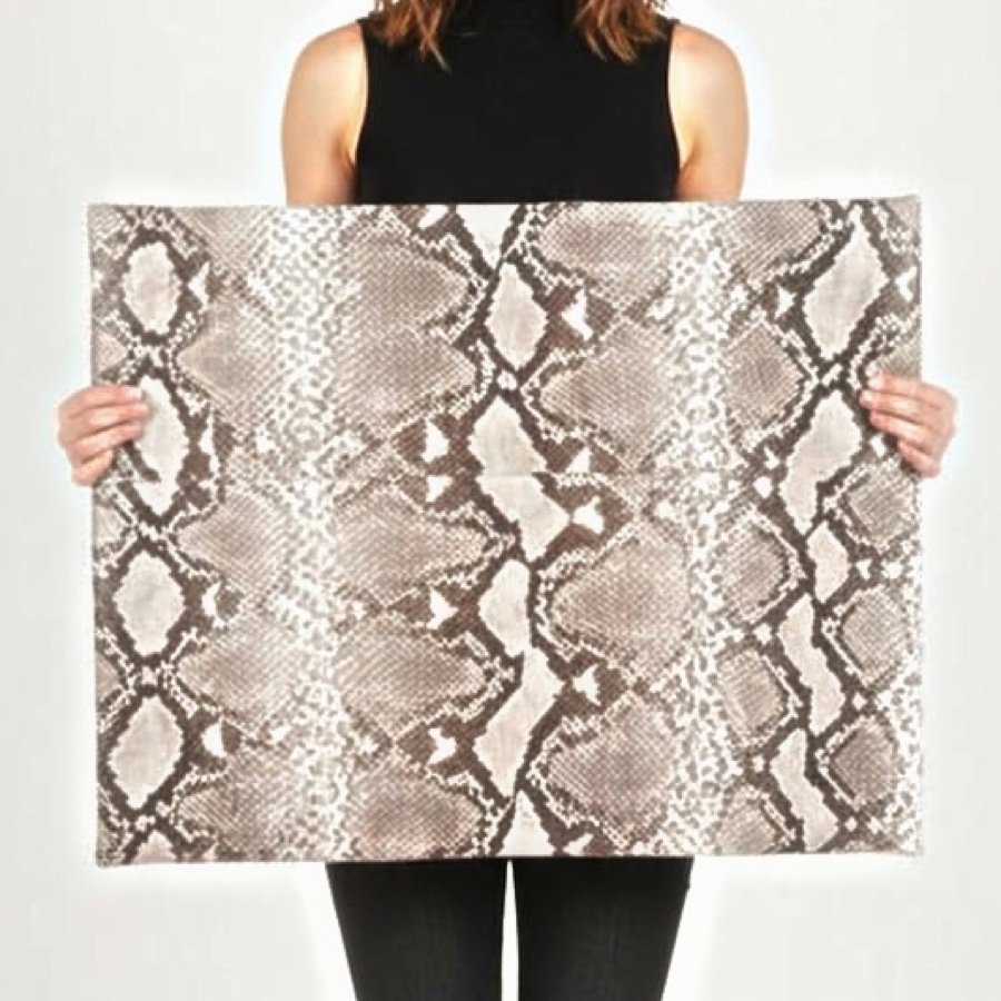 Master craftsperson holding CITES-certified python leather hide — Batavia Exotic Leather manufacturing facility, Yogyakarta Indonesia